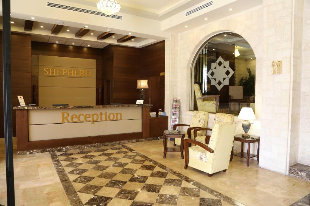 a hotel lobby with a reception desk and a checkered floor at Shepherd Hotel in Bethlehem