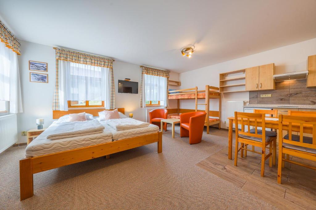 a bedroom with a bed and a dining room at Apartmány Koloniál in Rokytnice nad Jizerou
