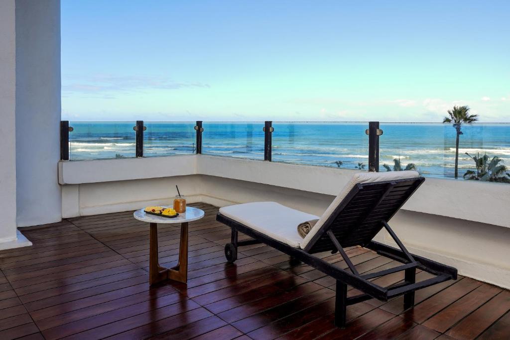 a chair on a balcony with a view of the ocean at Villa Blanca Urban Hotel in Casablanca