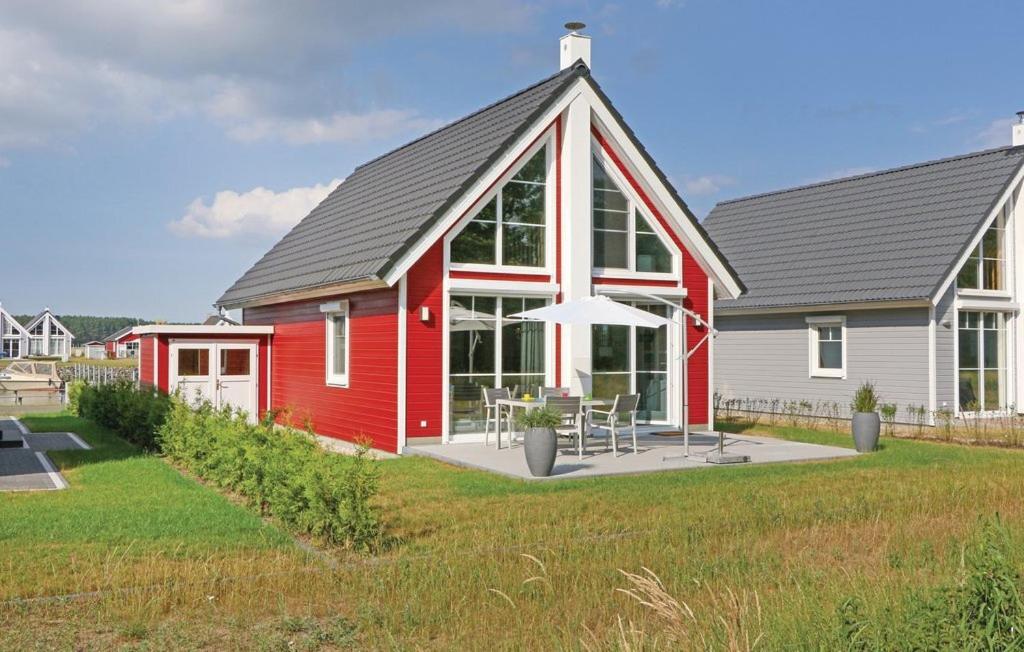 une maison rouge et blanche avec une table et un parasol dans l'établissement Haus Patricia, à Wandlitz