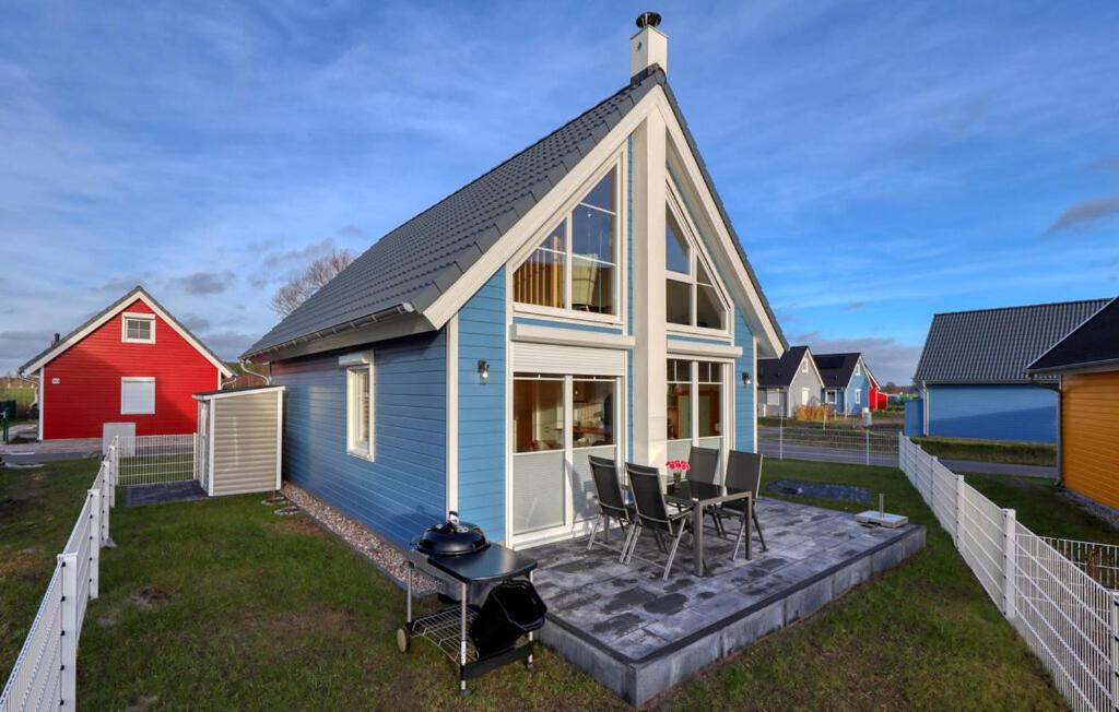 ein blau-weißes Haus mit einem Tisch und Stühlen in der Unterkunft Ferienhaus Hafenoase in Wandlitz