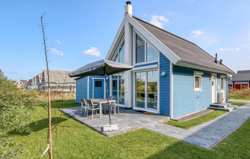 una casa blu con tavolo e ombrellone di Lavendel-Lodge a Wandlitz