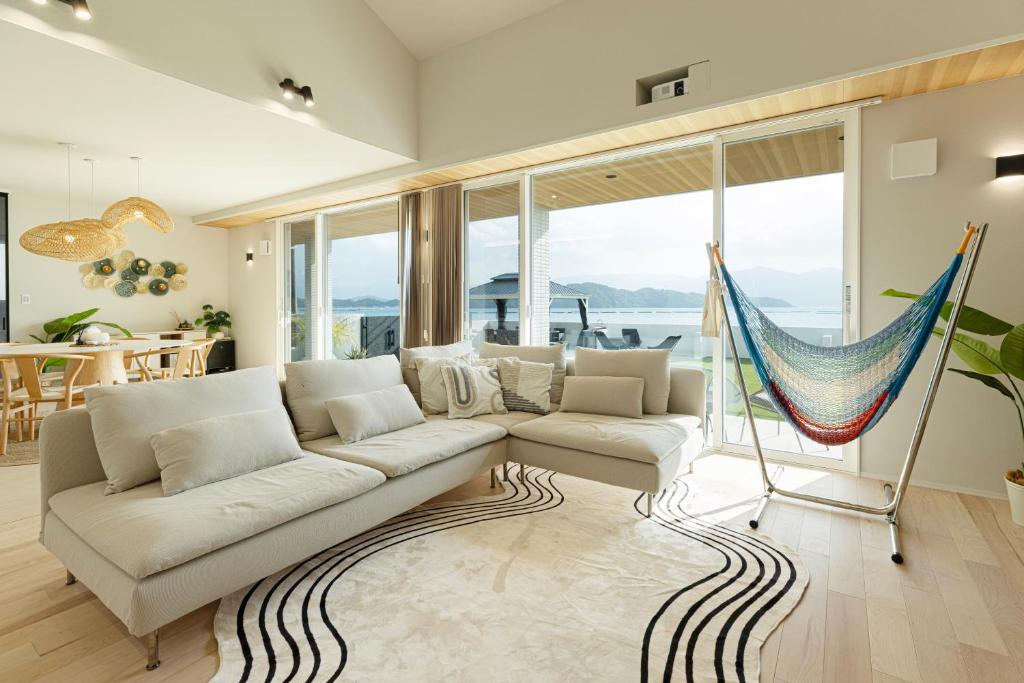 a living room with a couch and a hammock at Hale Moana in Itoshima