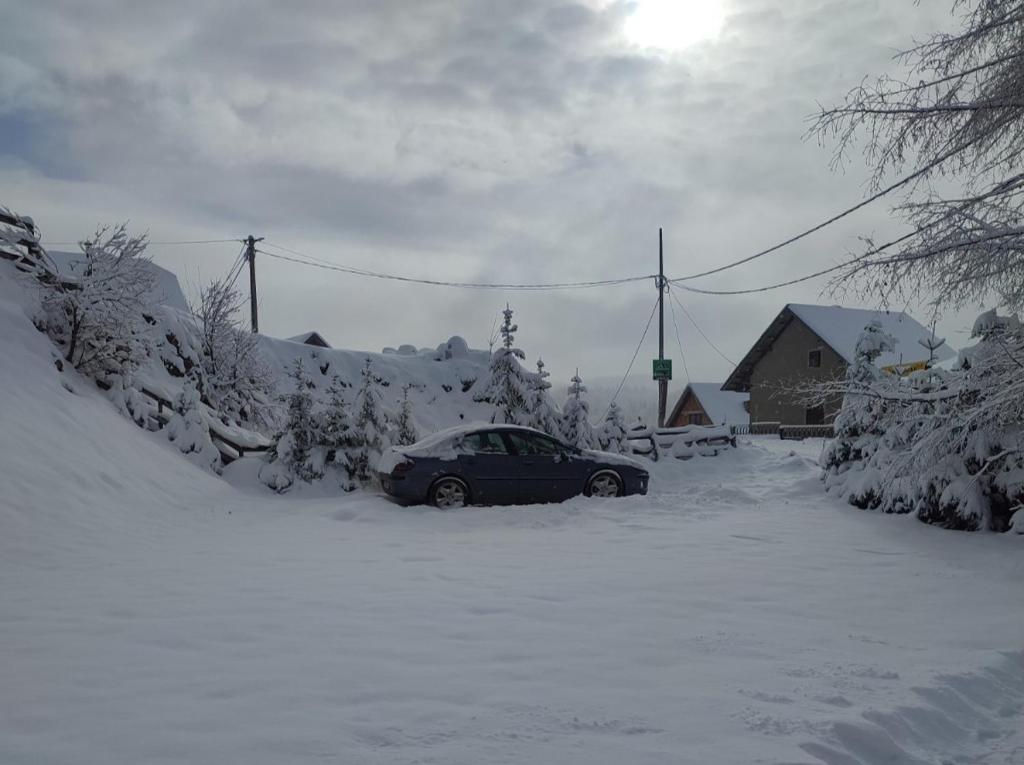 Sekulić にあるCozy Cabinの雪に覆われた駐車場に駐車した車