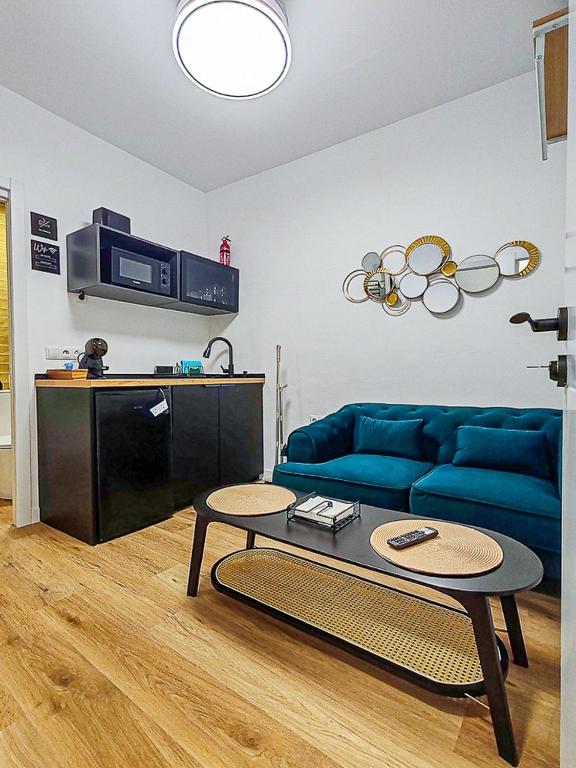 a living room with a blue couch and a table at Pettit Lion in Villena