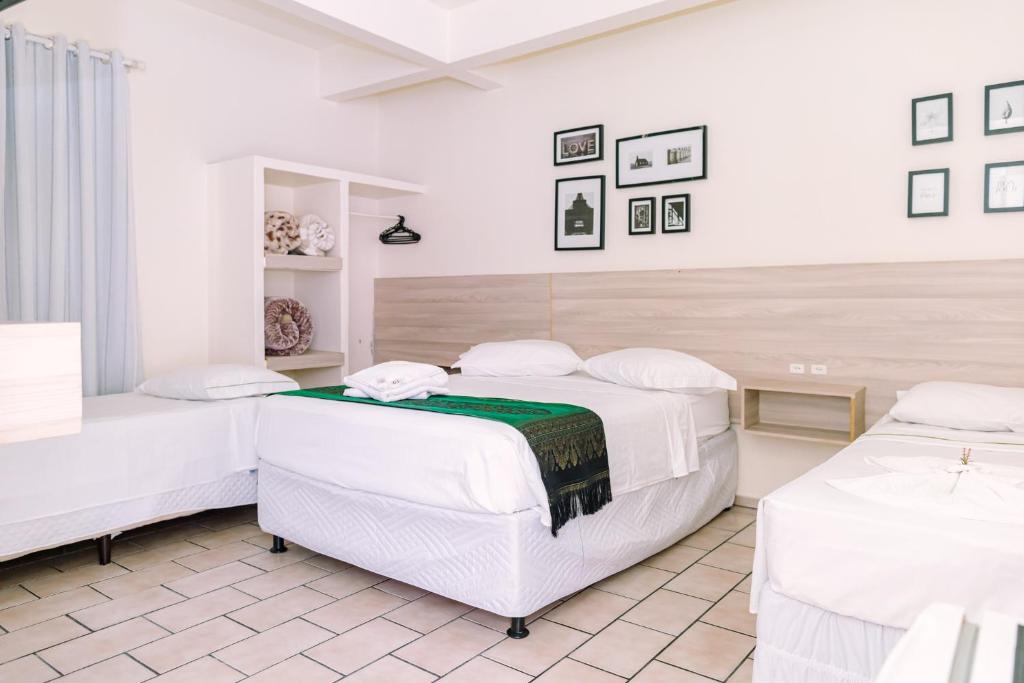 Hotel Dinamarca في باليريو كامبوريو: سريرين في غرفة بجدران بيضاء