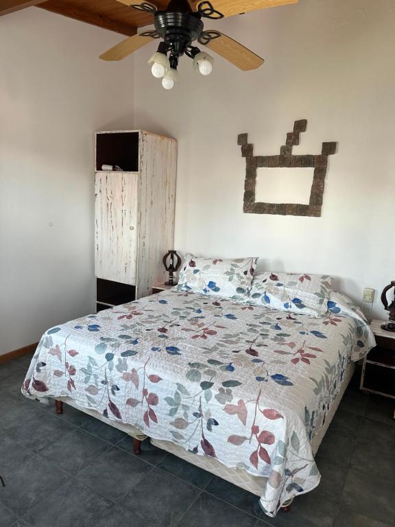 een slaapkamer met een bed en een plafondventilator bij Bilbao 44 in Santa Clara del Mar