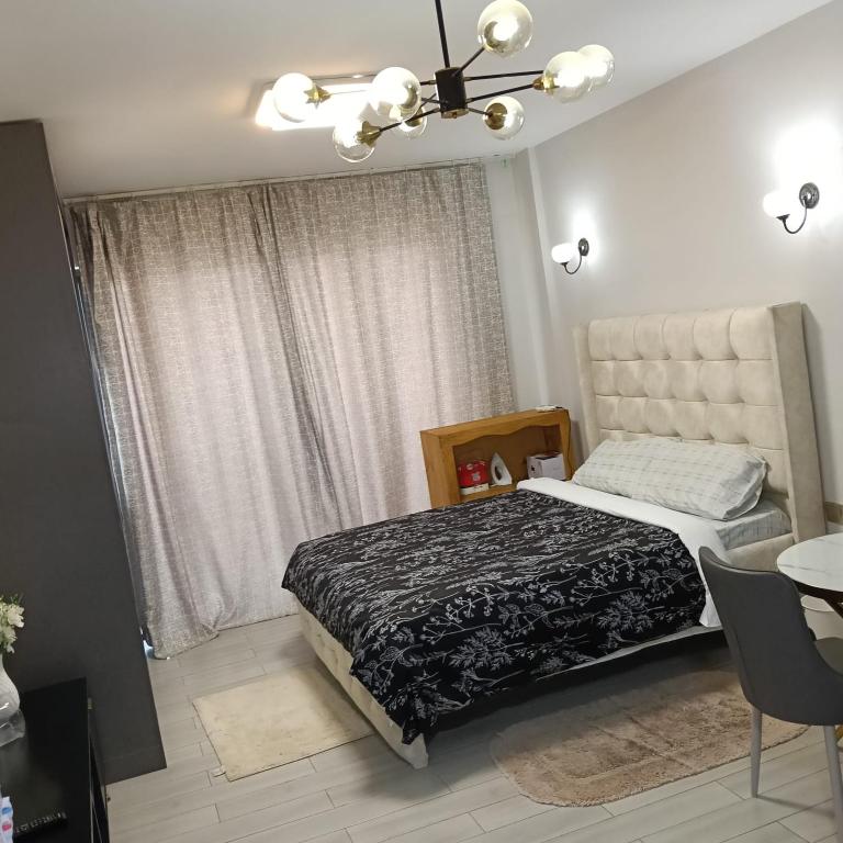 a bedroom with a bed and a chandelier at Quick Connect Studio Kileleshwa in Nairobi