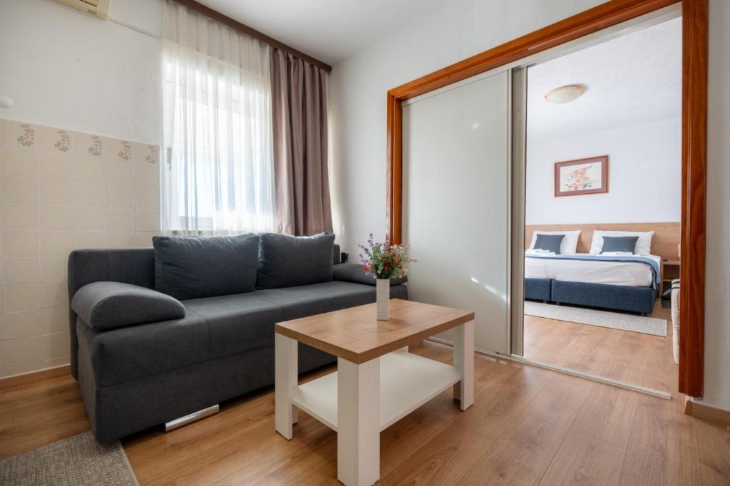 a living room with a couch and a bed at Apartmani i sobe Ina in Neum