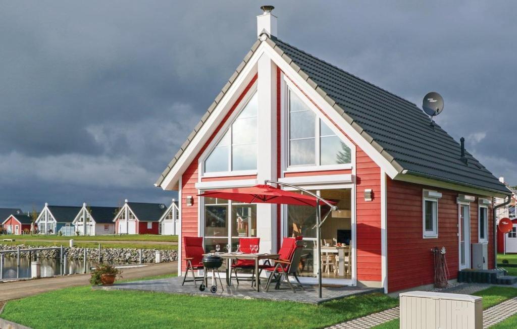 a red and white house with a table and chairs at Haus zum maritimen Blick in Wandlitz