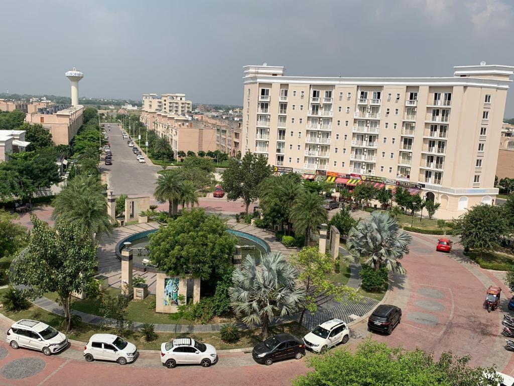 een parkeerplaats met auto's geparkeerd voor een groot gebouw bij Rajput Residency in Vrindāvan