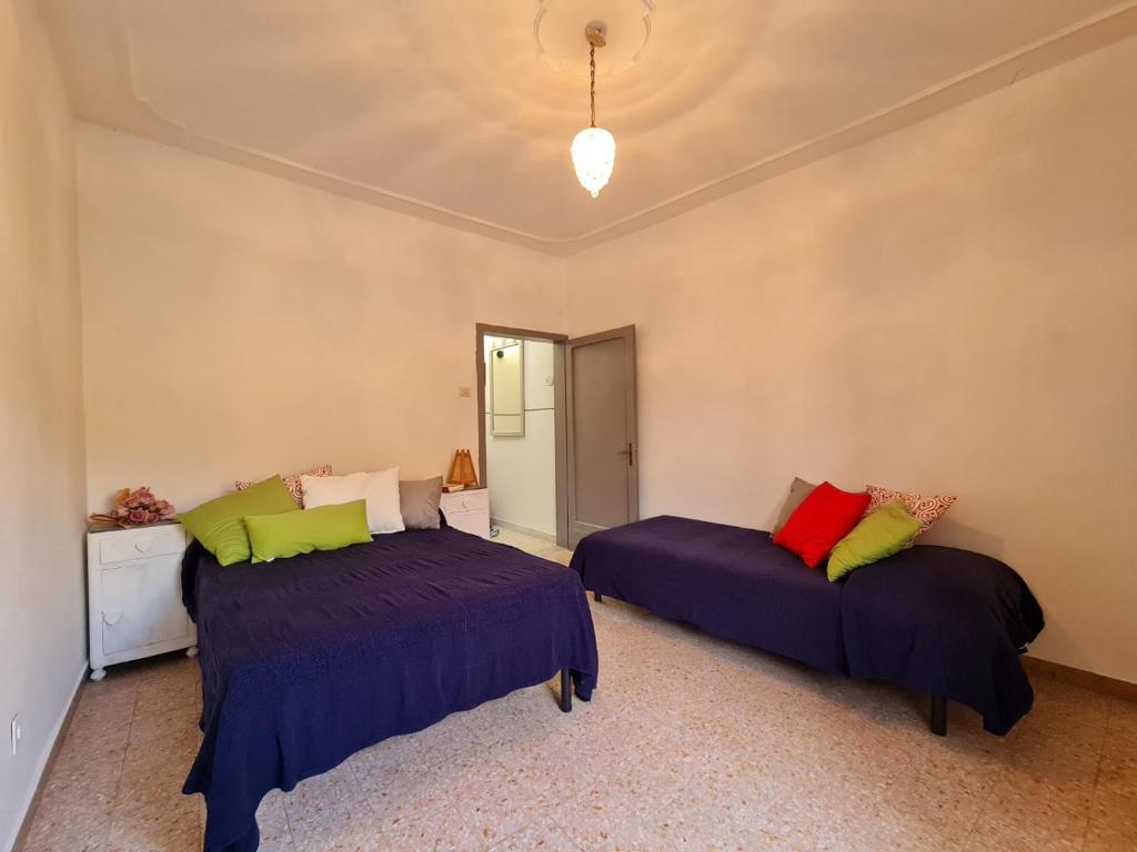a bedroom with two beds and a chandelier at Casa alta in Allerona