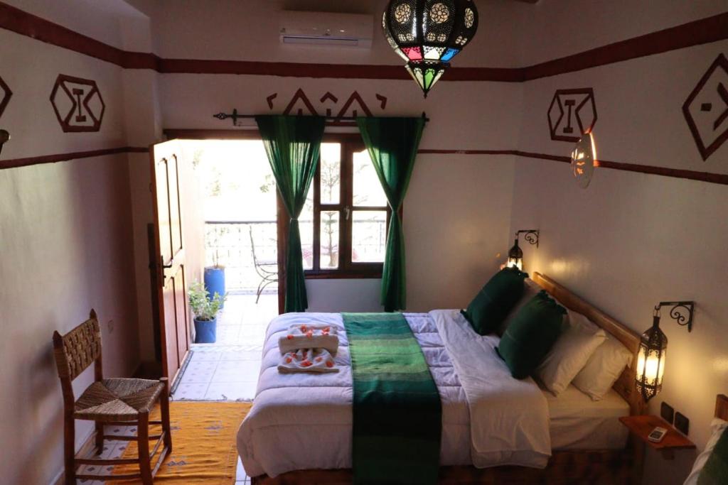 Un dormitorio con una cama grande en una habitación. en Maison d'Hôte Argana, en Aït Idaïr