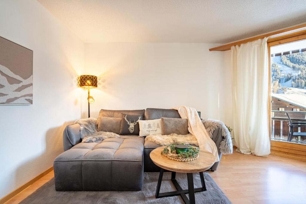 una sala de estar con un sofá y una mesa en A&Y Alpenchique Apartment Davos, en Davos
