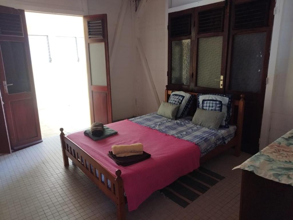 a bedroom with a bed with a pink blanket at la bella vita in Port-Louis