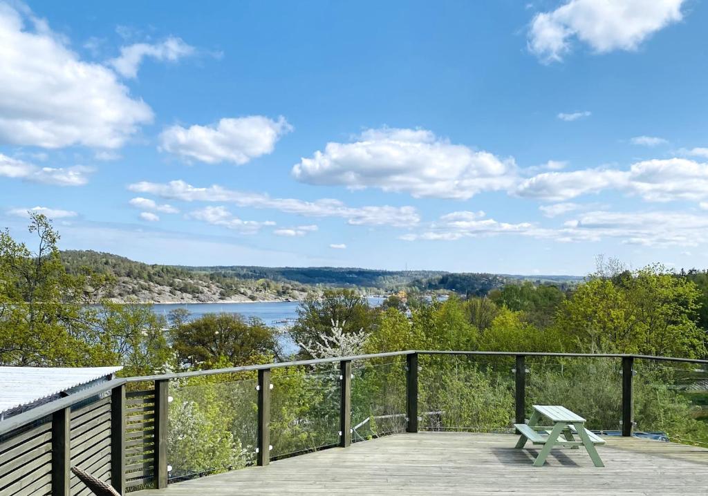 a picnic table on a deck with a view of a lake at Lovely view & walking distance to the beach SE09150 in Svanesund