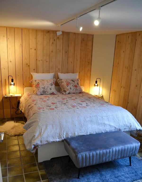 a bedroom with a large bed with wooden walls at Le Relais d'Hubert in Saint-Hubert