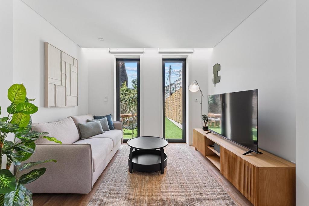 Una sala de estar con un sofá y un televisor. en Private Garden Oasis, A Charming Flat in Bonfim, en Bicas