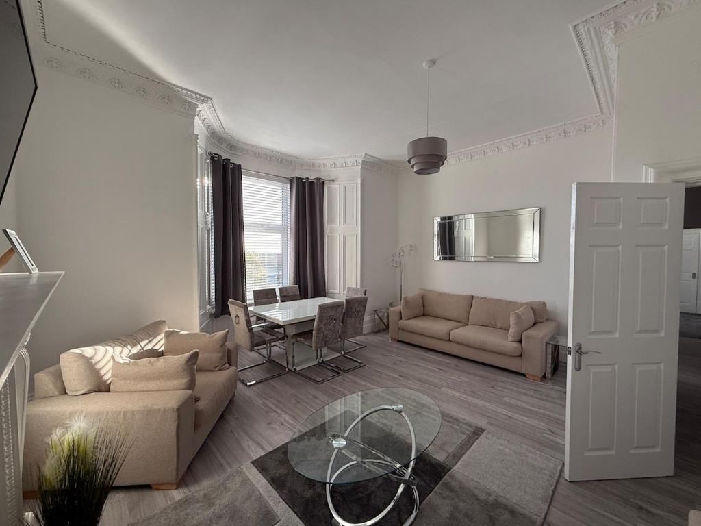 Casa Fresa - 31A High Street في Monifieth: غرفة معيشة مع أريكتين وطاولة