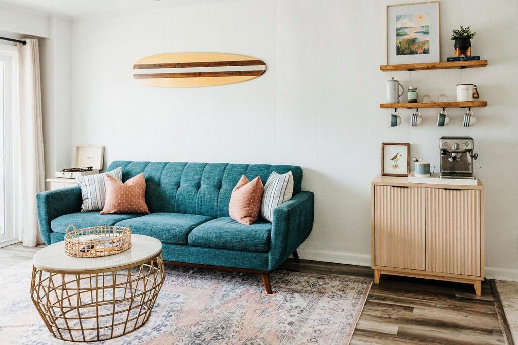 a living room with a blue couch and a table at Sanderling - Pet Friendly - Walk to Beach - Pool! in Holden Beach