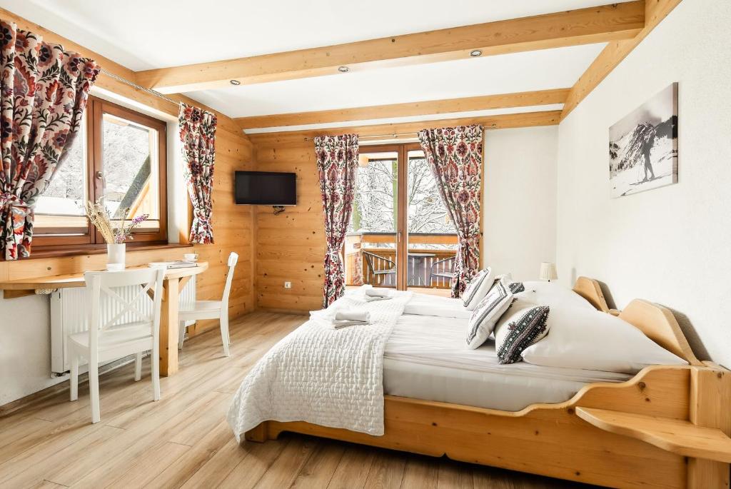 a bedroom with a large bed and a desk at Willa Vera Zakopane in Zakopane