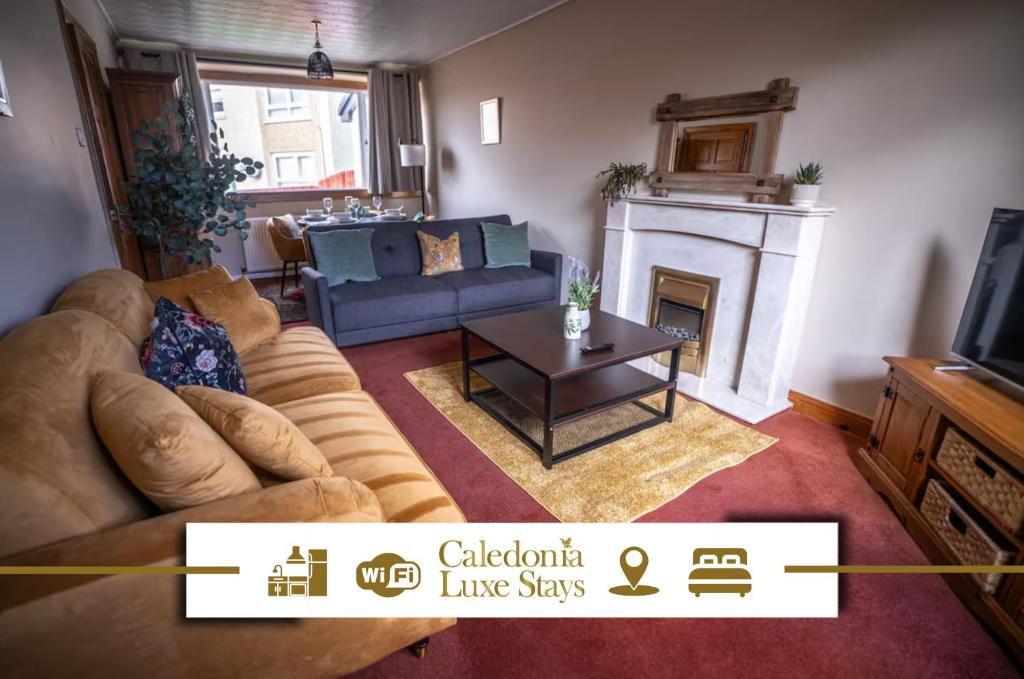 Una sala de estar con un sofá y una chimenea. en Muirhead House, en Motherwell