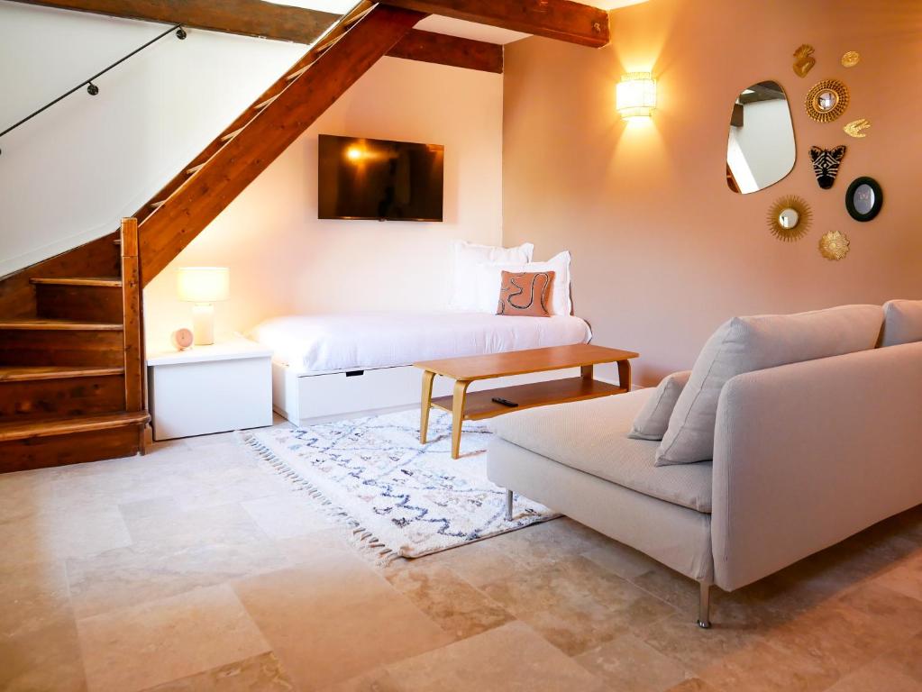 Gîte du Puy Drome Provençale Puygiron في Puygiron: غرفة معيشة بها سرير وأريكة