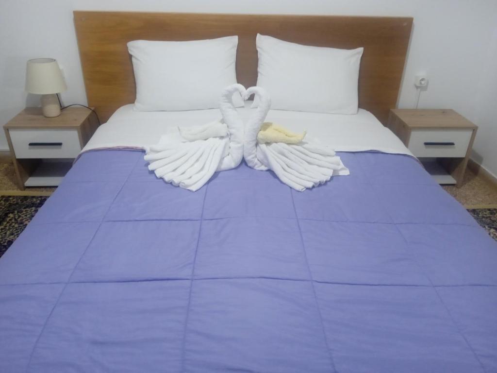 a bed with white sheets and angel wings on it at Classic Guesthouse Nafplion in Nafplio