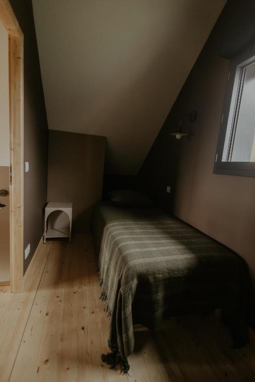 a small bedroom with a bed in a attic at Aux Choses Simples in Pradiers