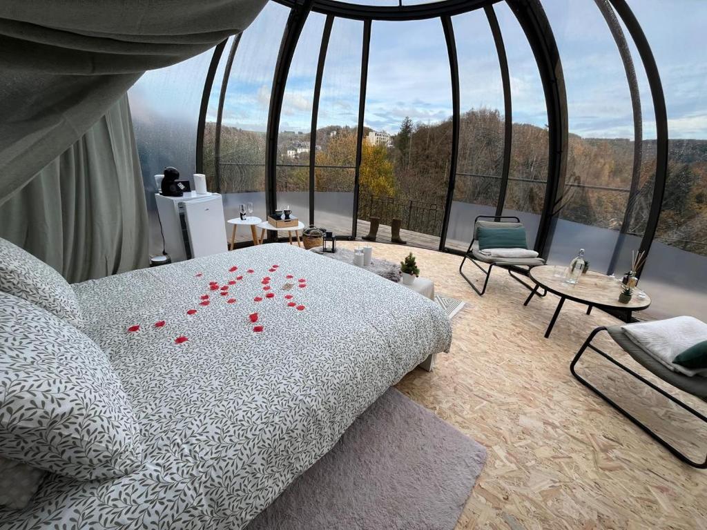 a bedroom with a bed with red flowers on it at Entre Ciel et Rivière in Bouillon
