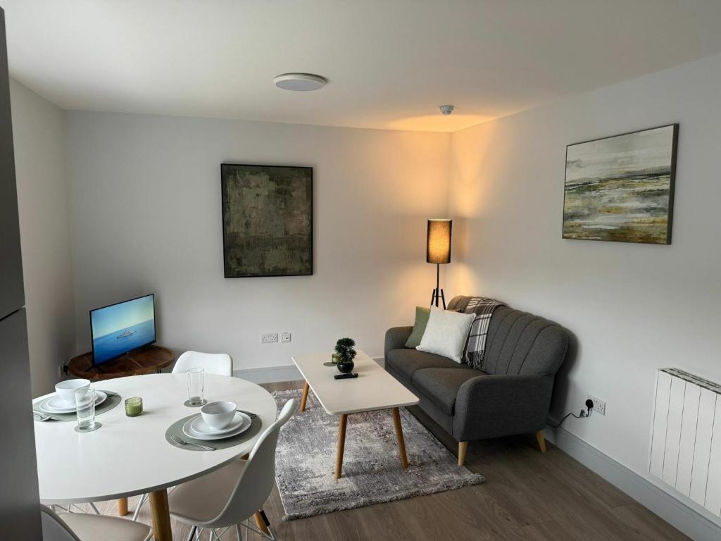 a living room with a table and a chair and a couch at Refurbed 4BDR Home on Dock Road Near City Centre in Limerick