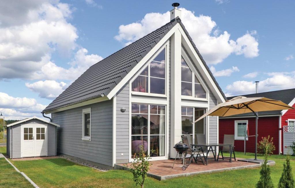 a house with a pitched roof with a patio at Lykkebo in Wandlitz