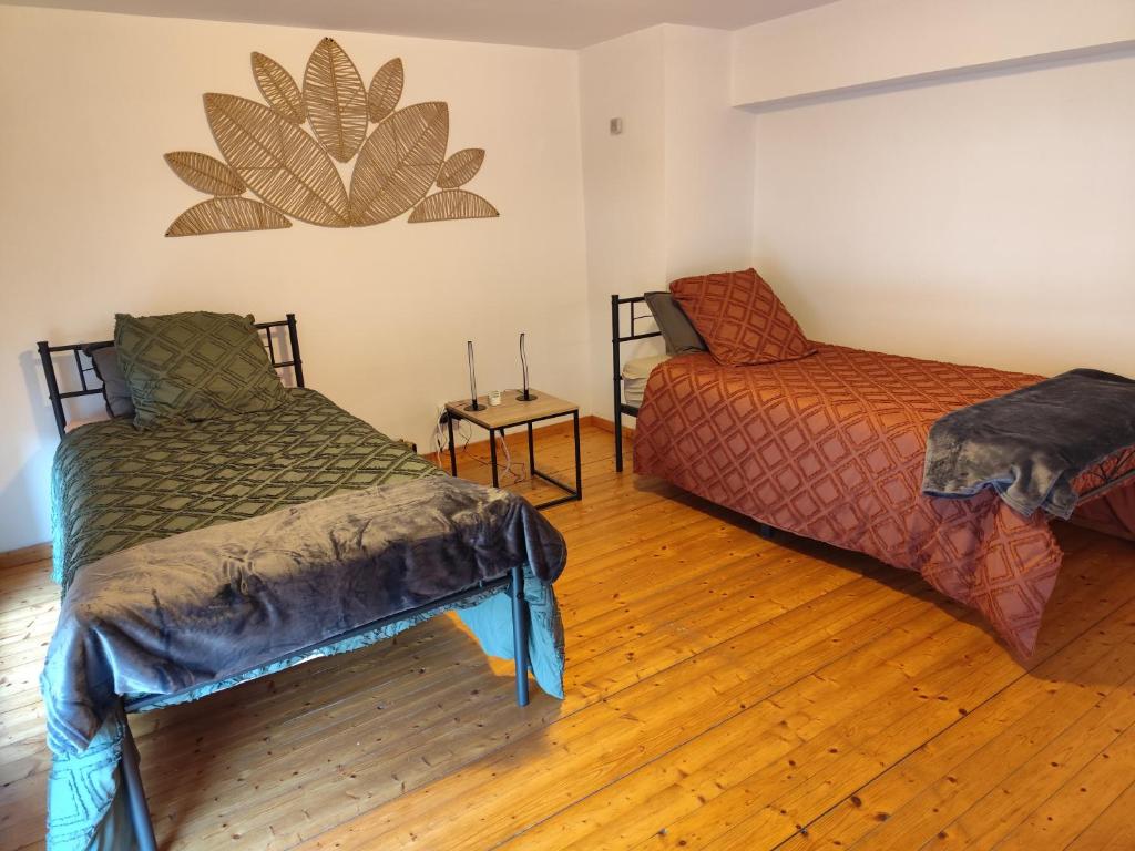 a room with two beds and a chair in it at Appartement 3 Chambres Bollezeele in Bollezeele