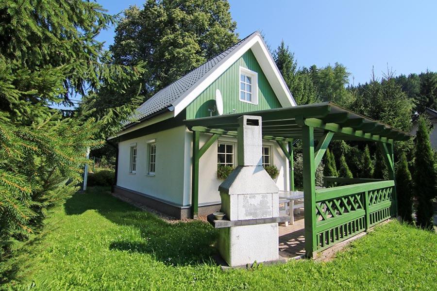 a small green and white house with a porch at Domek Markoušovice in Velké Svatoňovice