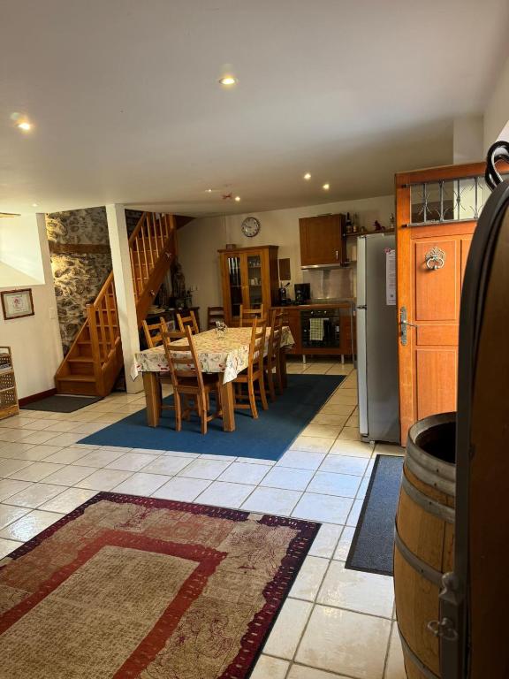 a kitchen and dining room with a table and a refrigerator at Grange des Taouré in Vignec