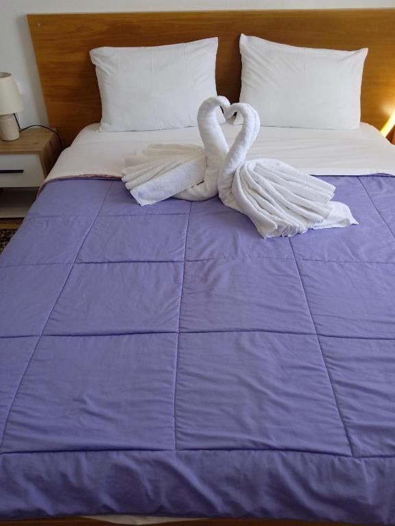 two swans sitting on top of a bed at Classic Guesthouse Nafplion in Nafplio