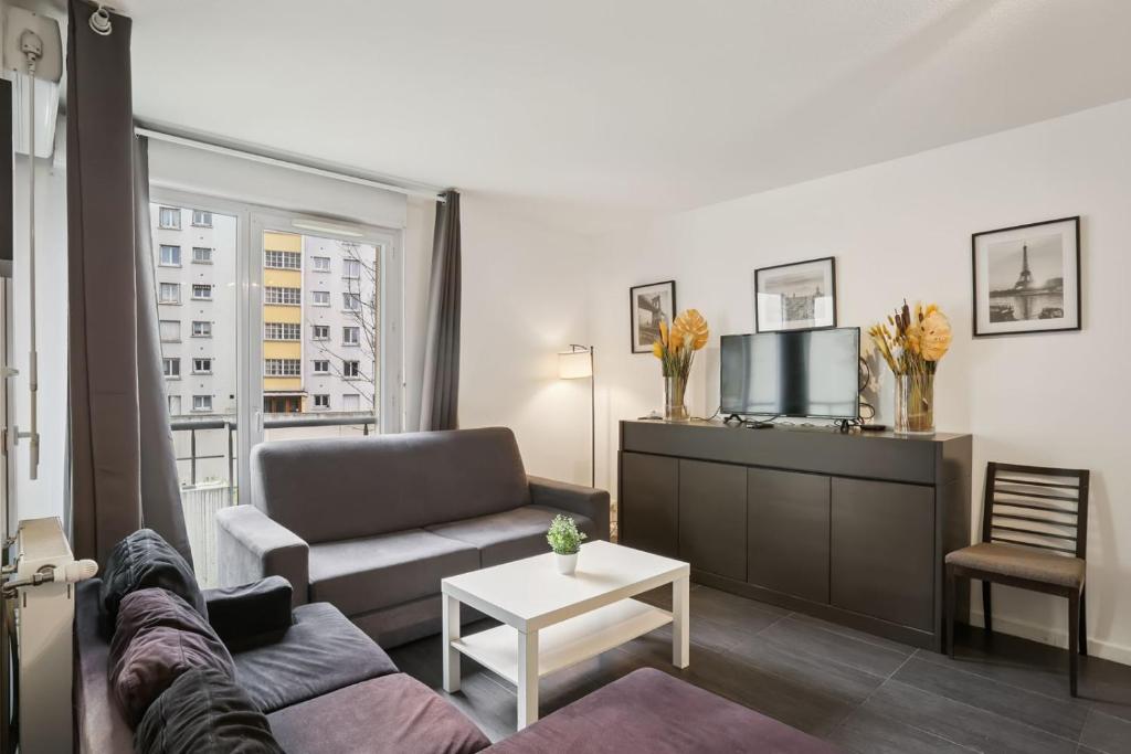 Una sala de estar con un sofá y un televisor. en Superbe 90M2, chic & cosy avec Parking privé et Terrasse - 10pers, en Villeurbanne