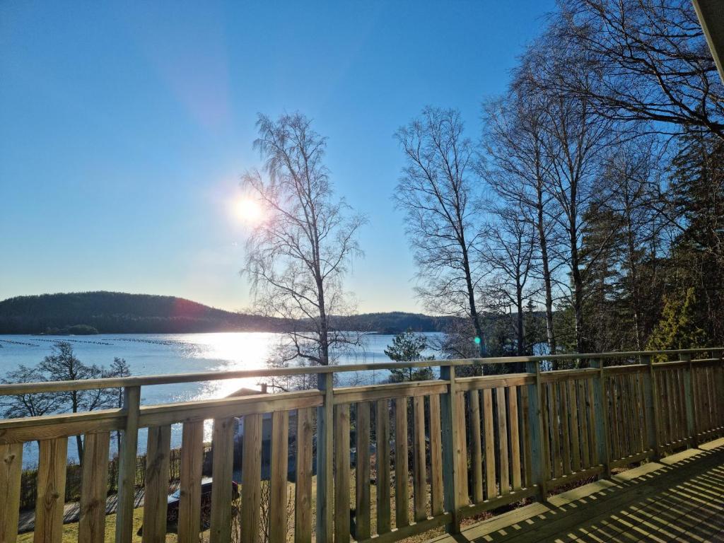 a view of a lake from a wooden fence at Holiday home- 50m to sandy beach at Kavlanda Brygga SE09147 in Tviklippan