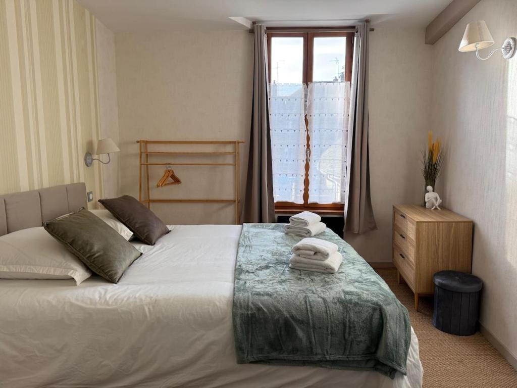 een slaapkamer met een bed met handdoeken erop bij L'Evasion Troyenne T21 in Troyes