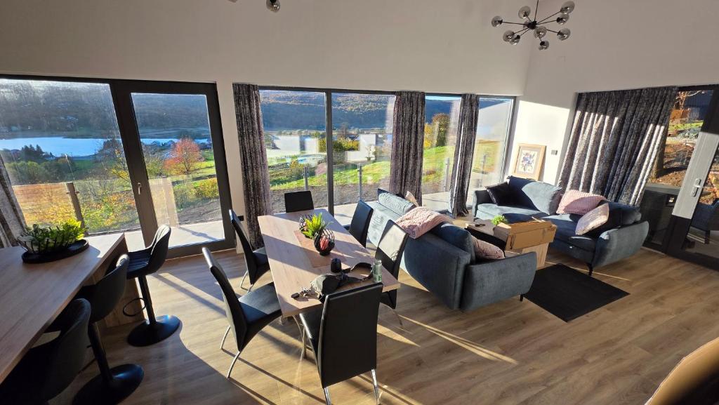 a living room with a lot of windows at Forest Edge Lake House in Desmerice
