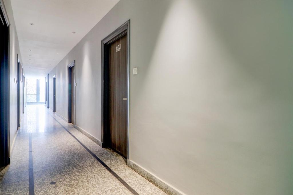Super Hotel O Gold Inn في Rohtak: ممر في مبنى به باب على الحائط