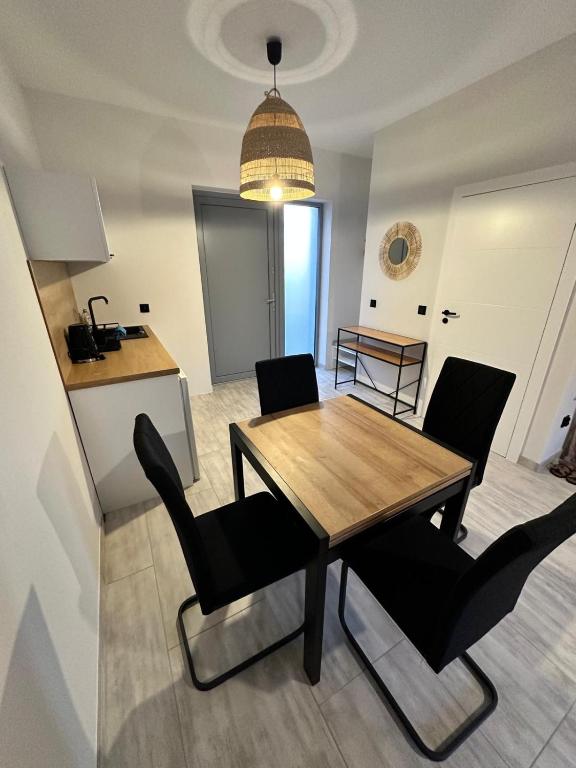 a dining room with a table and chairs and a kitchen at Przystań Dębki in Dębki