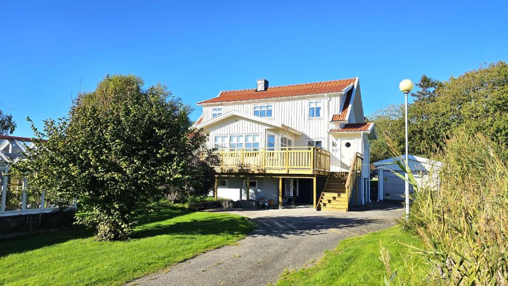 a large white house with a porch and a driveway at Family-friendly house close to sea & nature in Klövedal SE09145 in Viks Ödegärde