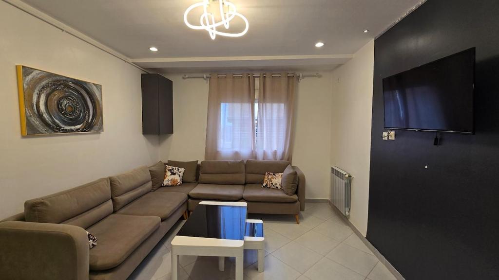 a living room with a couch and a flat screen tv at T2 Cosy & Central Akid Lotfi in Oran