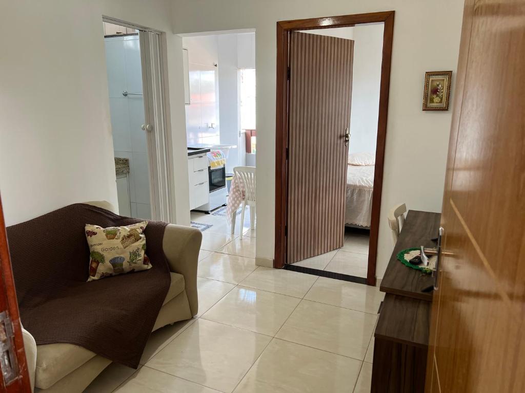 Una sala de estar con un sofá y una puerta a un dormitorio. en Apto Ninho Sereno em ilheus, en Ilhéus
