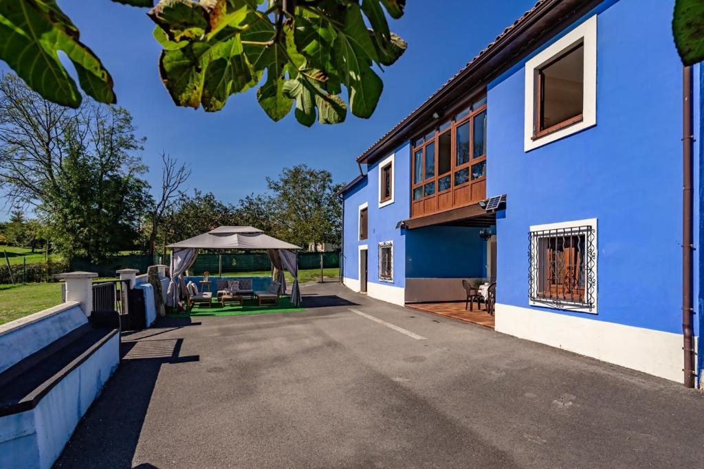 Un edificio azul con un paraguas afuera. en La Piñera, pola de Siero, en Siero