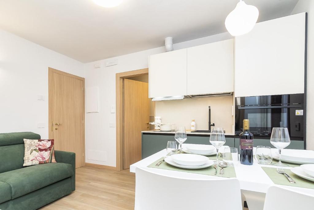 a kitchen and living room with a table with wine glasses at Larice&Ribes Apartments in San Vito di Cadore