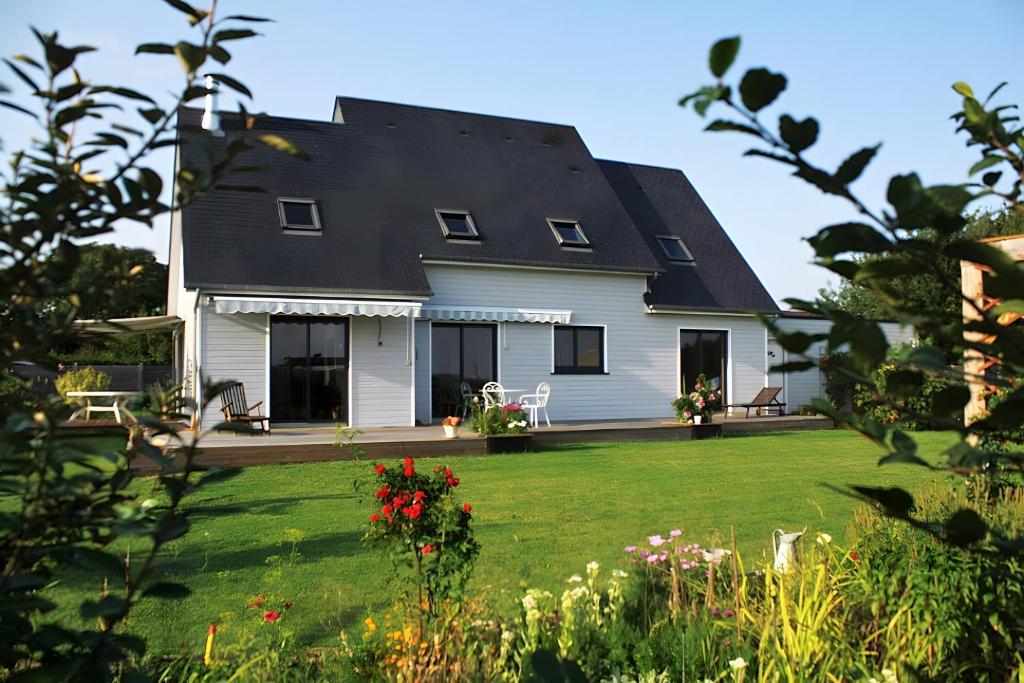 ein weißes Haus mit einem schwarzen Dach und einem Hof in der Unterkunft La Morinière in Vieux