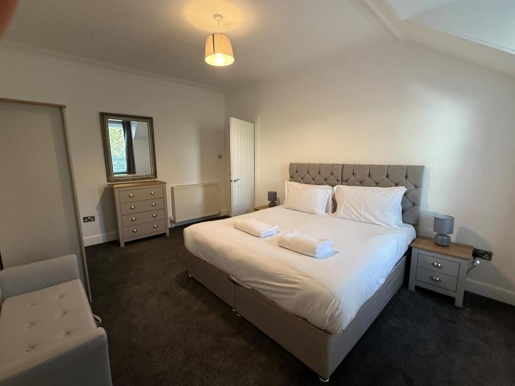 Casa Fresa - 31B High Street في Monifieth: غرفة نوم بها سرير أبيض كبير مع وسادتين