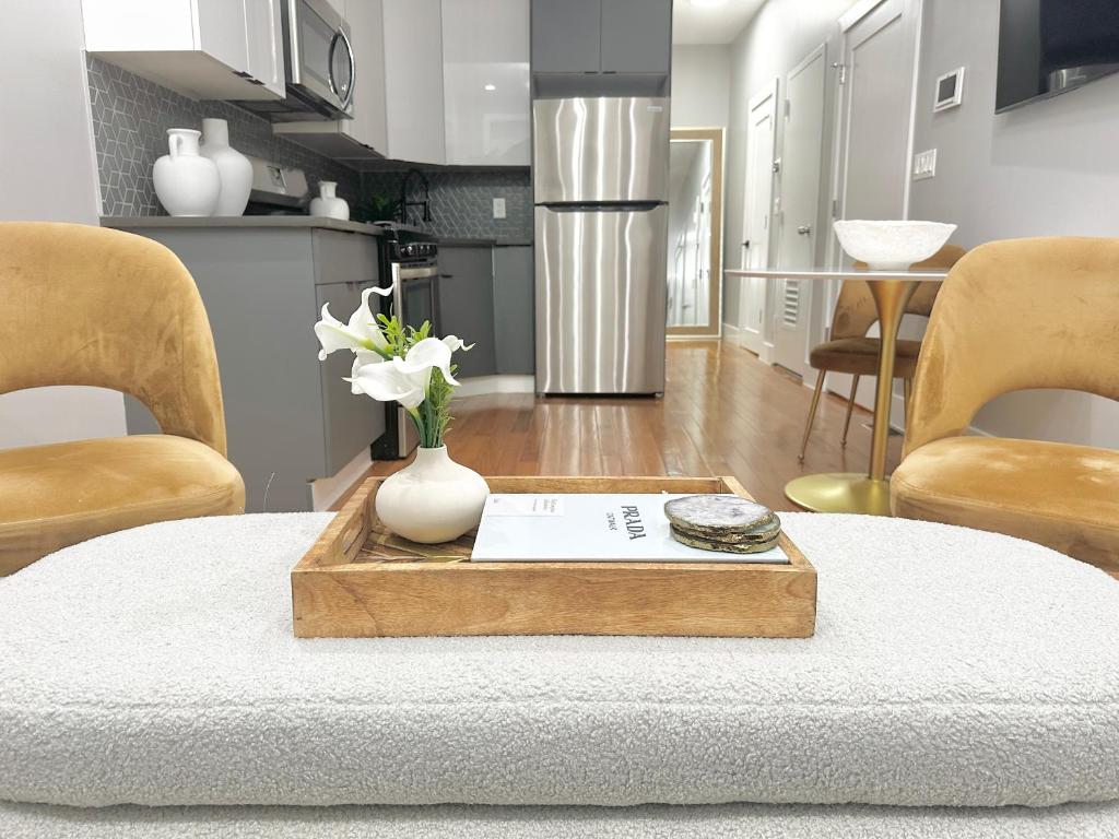 a living room with a table with a vase of flowers at Dream Home Close to the Center of NYC in Mott Haven